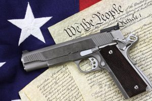 Gun lying on top on the U.S. constitution - Springfield firearm attorney
