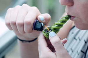 person smoking from a glass pipe - drug possession Missouri