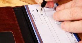 person writing a check - forgery in Missouri
