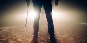 man with crowbar with car headlights in background - Missouri Trespassing