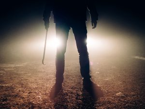 man with crowbar with car headlights in background - Missouri Trespassing