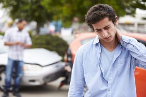 car accident injury man walking away from car accident in pain