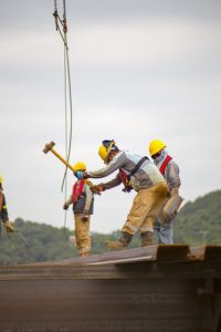 construction workers hammering a roof